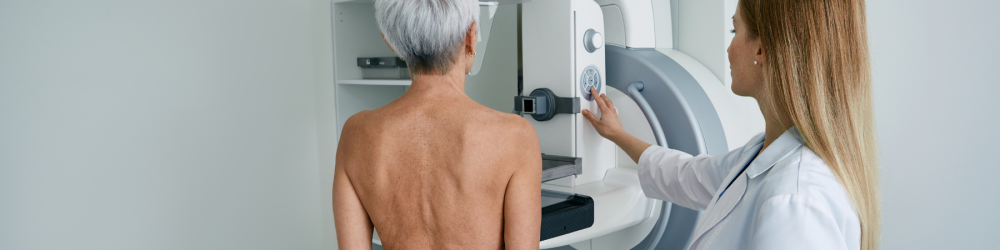 Paciente realizando exame de mamografia, utilizado em comparação com ultrassom para diagnóstico das mamas.